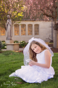 First Communion portrait sitting in grass