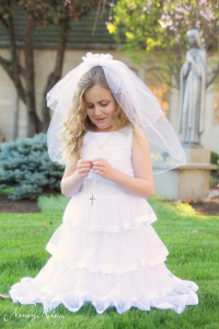 First Communion portrait kneeling in grass