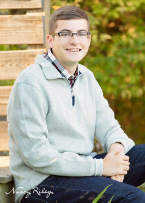 Senior boy seated on bridge