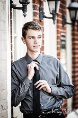 Senior boy straightening tie